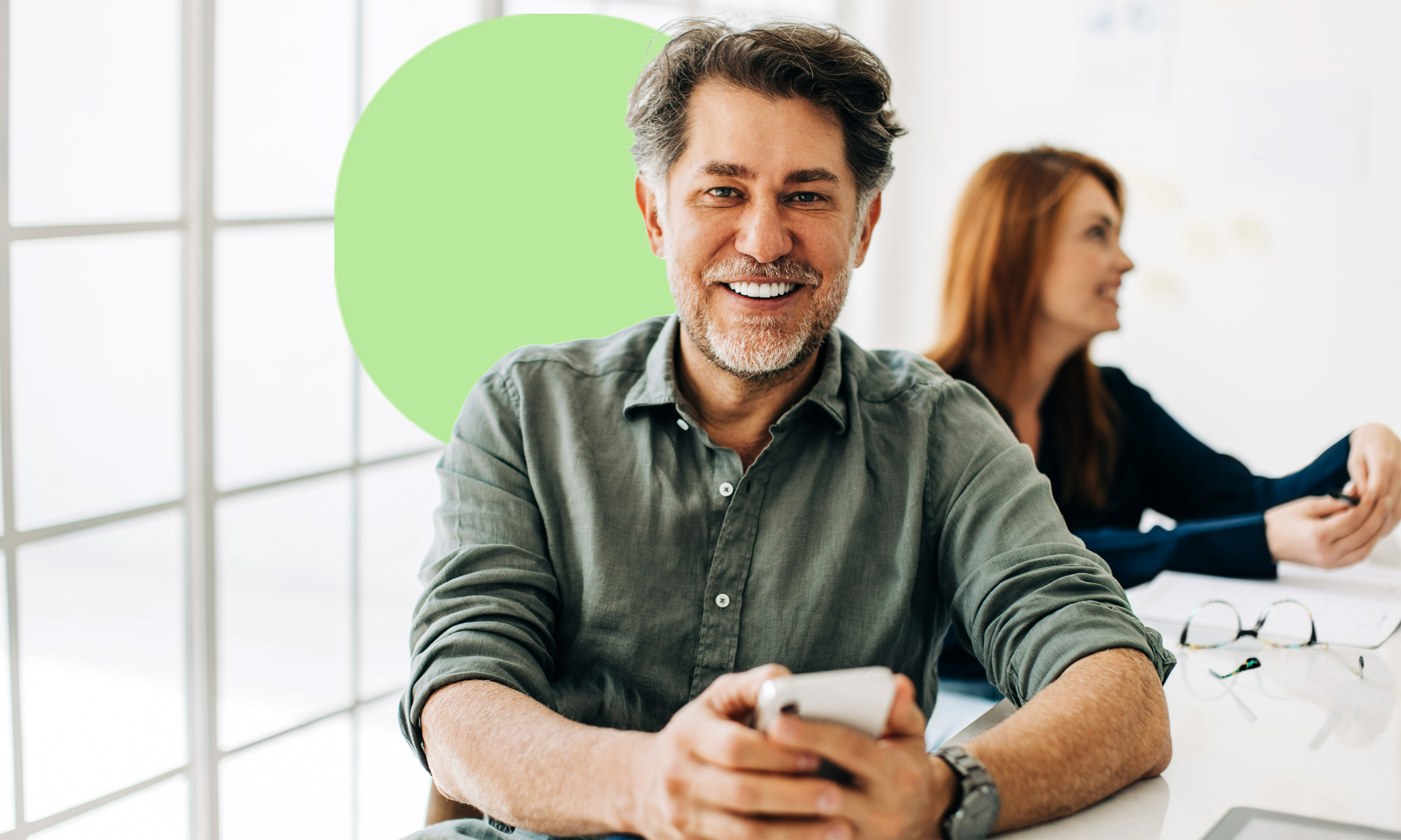 Mann mit einem Mobiltelefon in einer Arbeitsumgebung