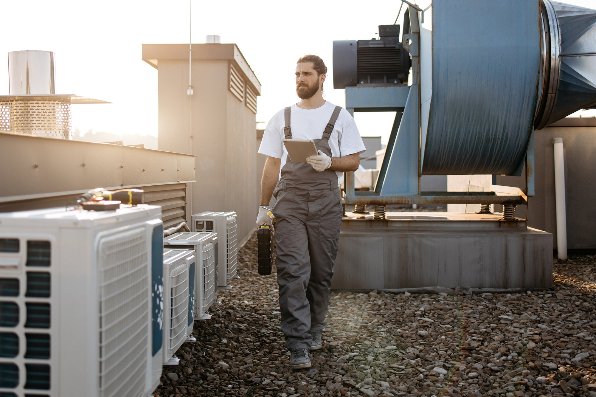 Mann läuft mit einem Tablet in der Hand auf dem Dach